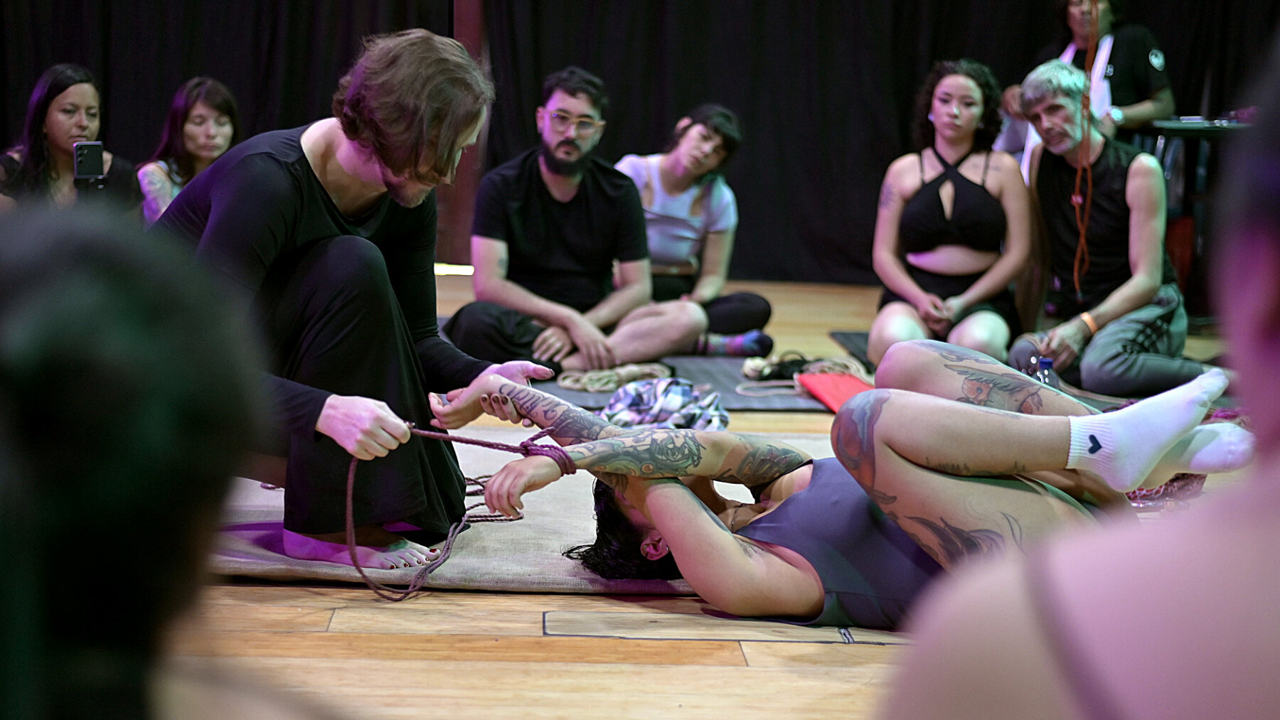 Renée de Sans teaching a shibari workshop on the emotional side of rope, participants seated in a circle in Bogotá